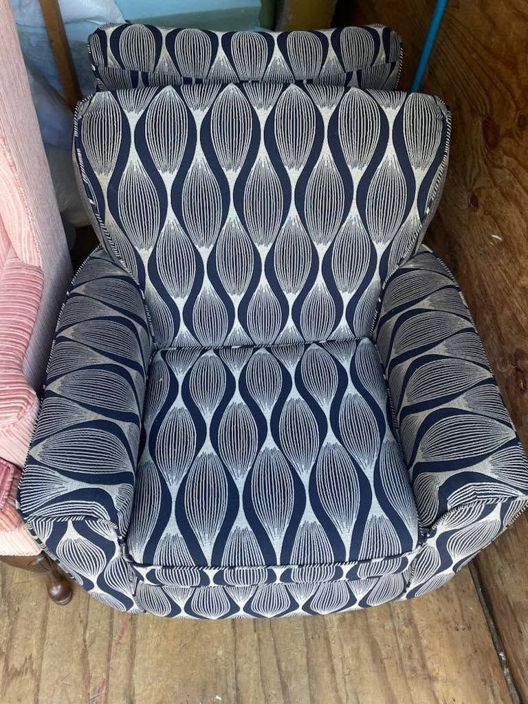 Armchair with a black and white patterned fabric, set on wood flooring.