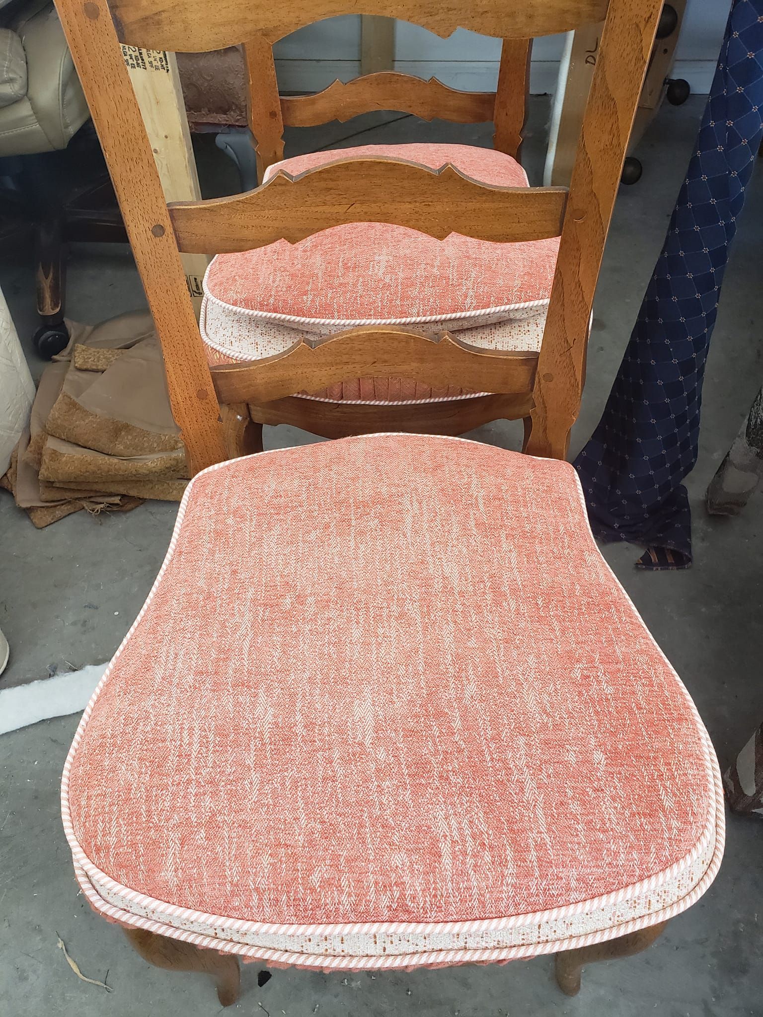 Three wooden chairs with peach-colored, patterned cushions.