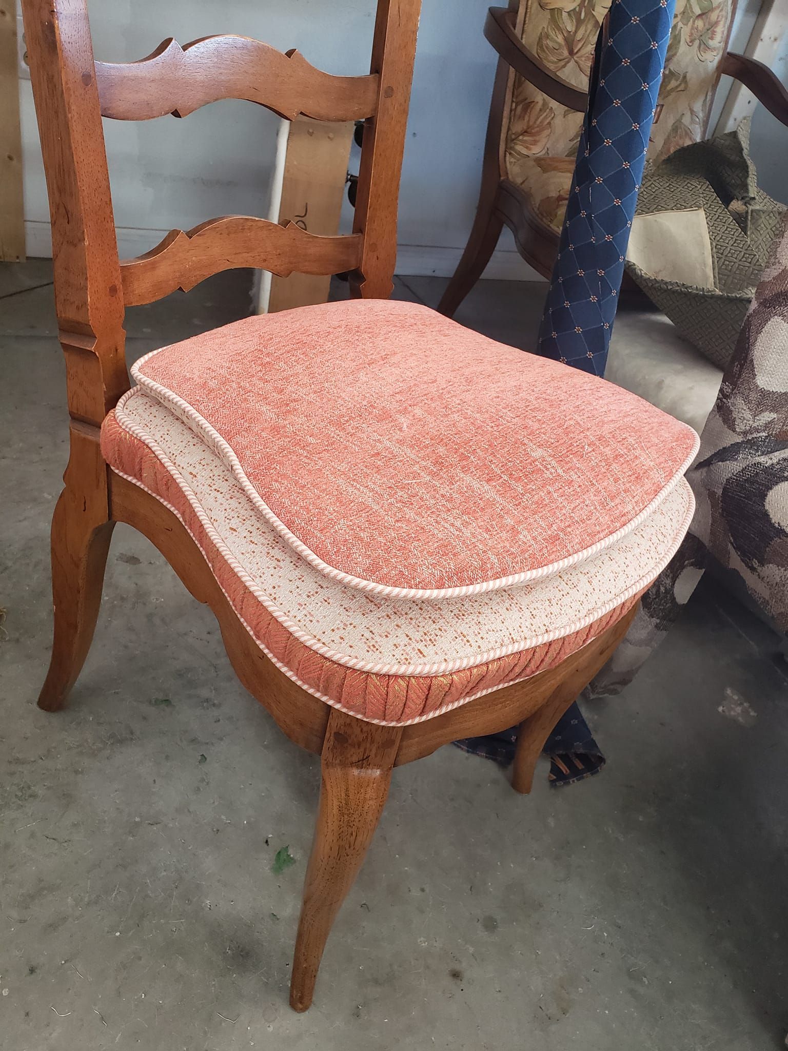Wooden chair with layered seat; peach and white upholstery.