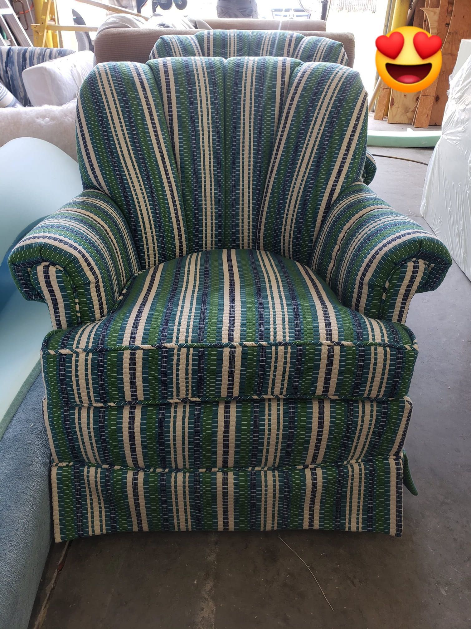Green striped armchair, classic style, in workshop setting.