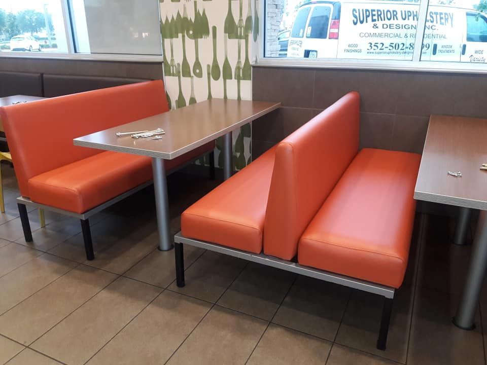 Orange booth seating and tables in a restaurant setting.