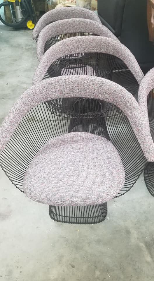 Several wireframe chairs with round seats and backs, gray fabric padding.