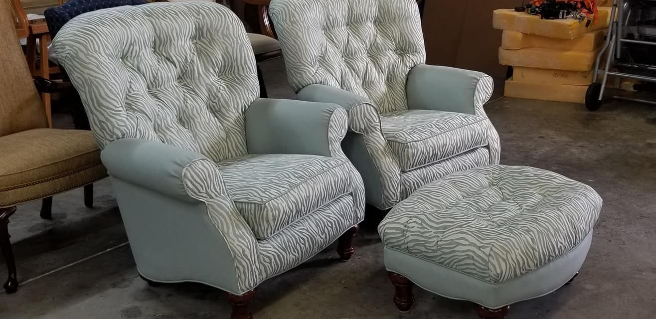 Two armchairs and an ottoman upholstered in patterned fabric with light blue accents.
