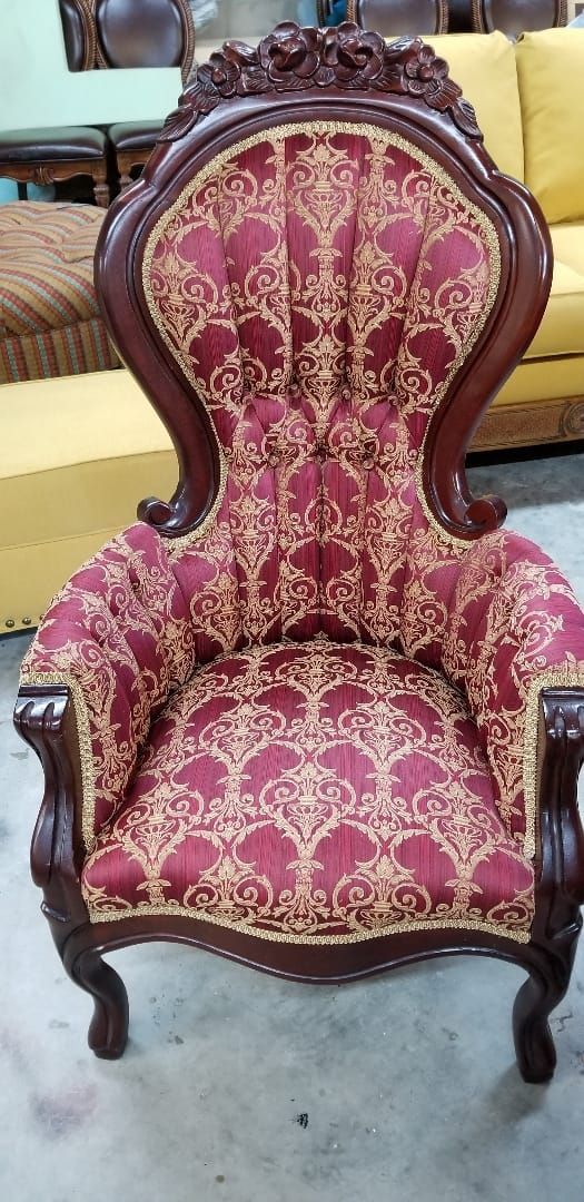 Burgundy and gold patterned ornate armchair with dark wooden frame.