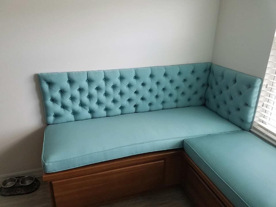 Blue tufted corner bench with wooden base.