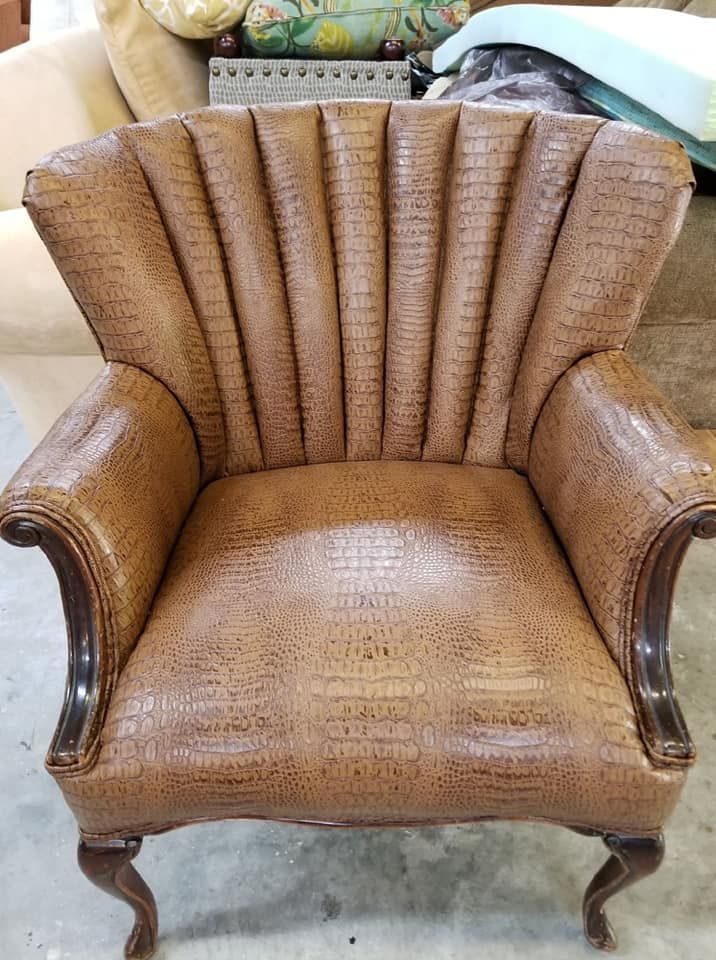 Brown faux alligator armchair with arched back, wood trim, and cabriole legs.