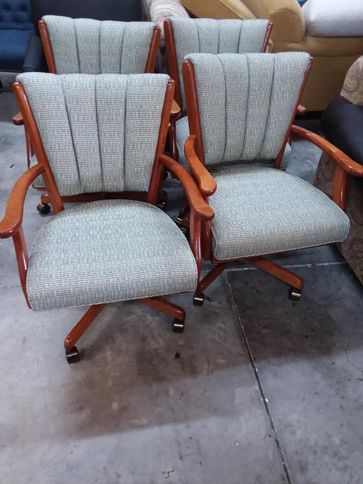 Four light gray upholstered chairs with wooden frames and armrests.