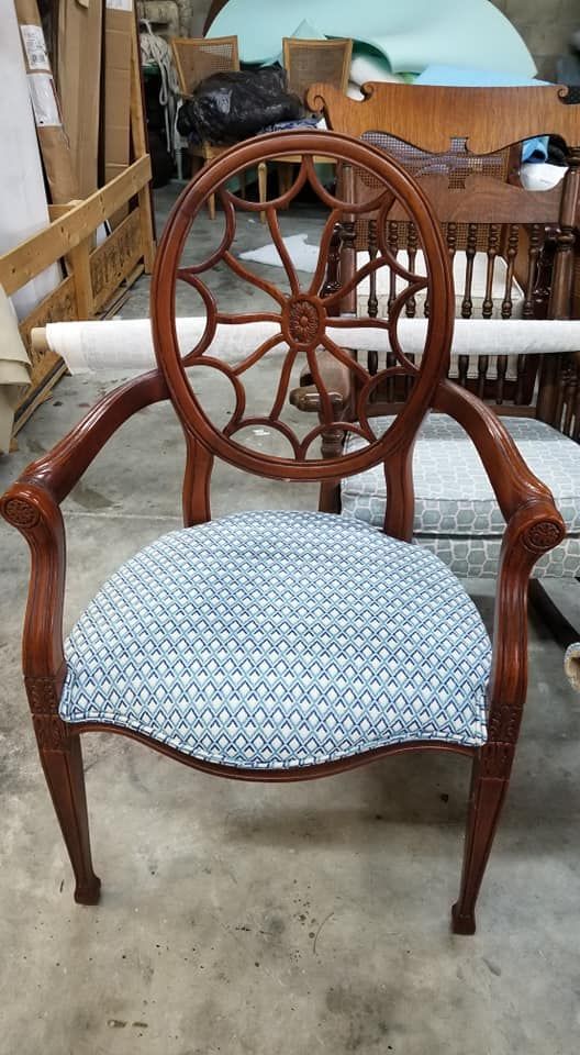 Brown wooden armchair with wheel-shaped back, blue patterned seat.