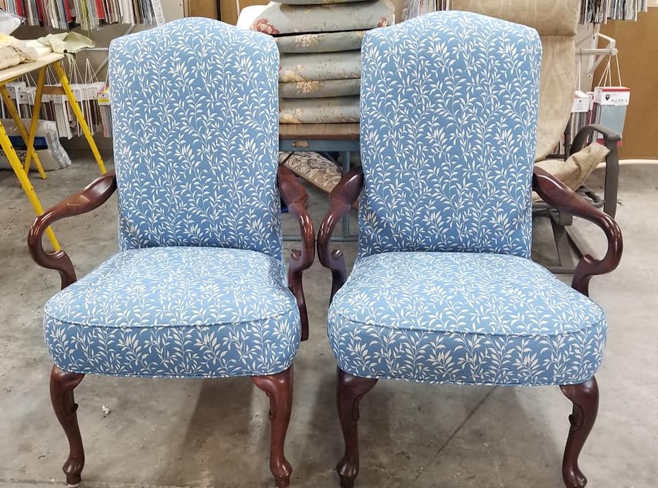 Two upholstered armchairs with blue patterned fabric, dark wood frames, and high backs.