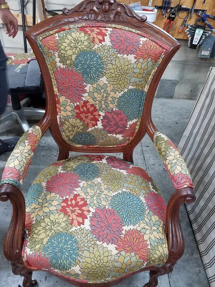 Antique armchair with floral fabric, wooden frame.