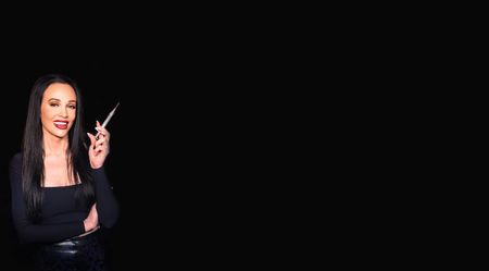A woman is holding a pair of scissors in her hand.