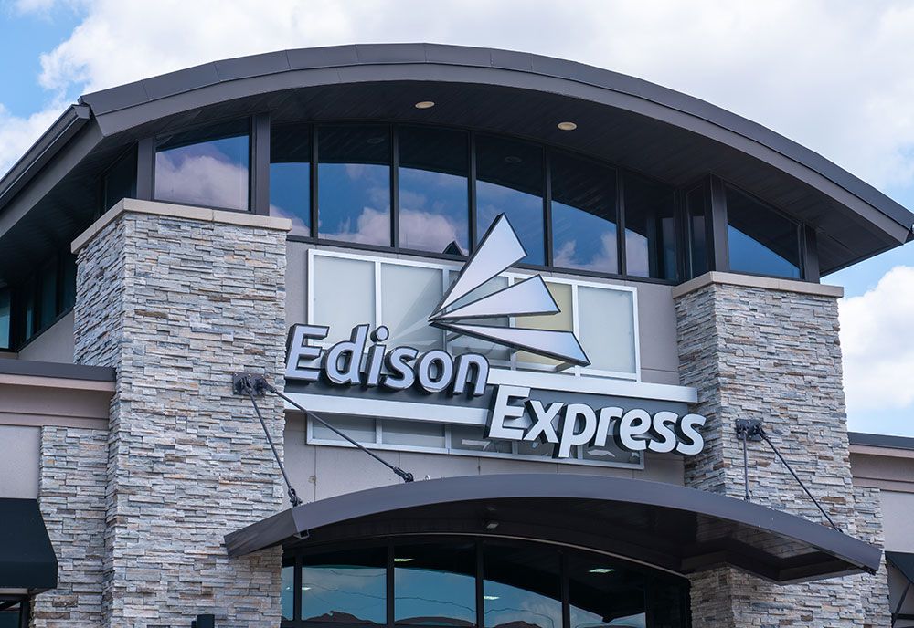 Edison Express storefront with a stone facade and sign against a blue sky.