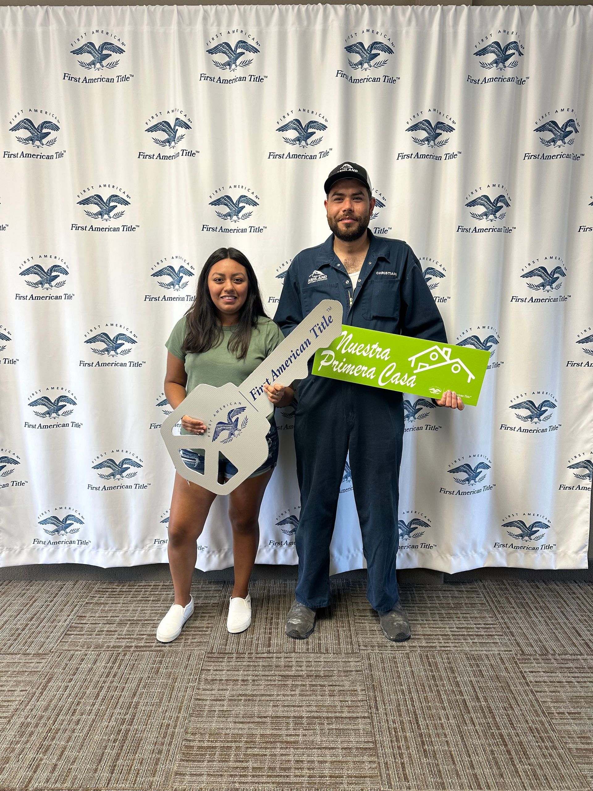 A man and a woman are standing next to each other holding a large key.