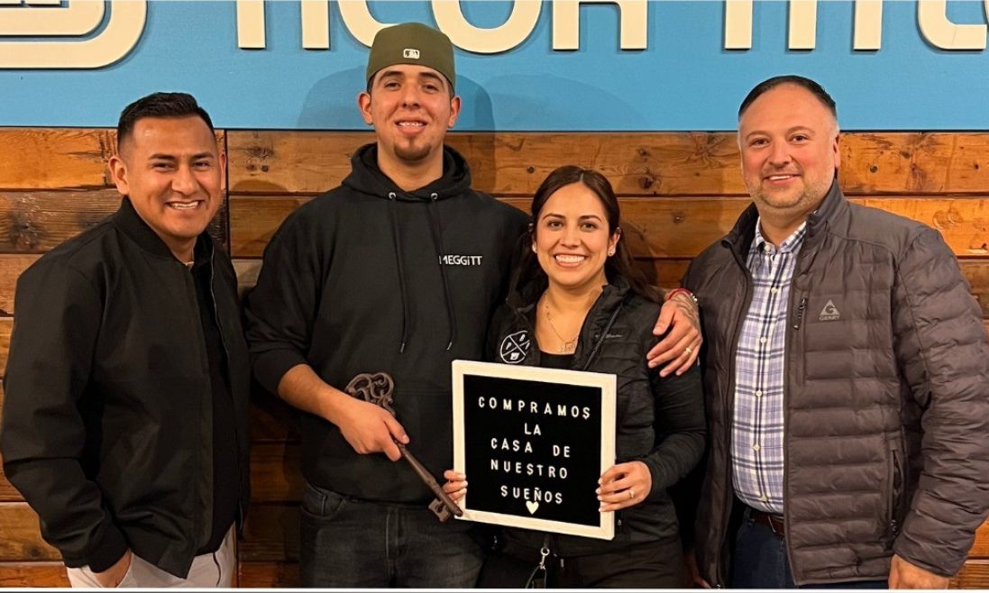 A group of people standing next to each other holding a sign