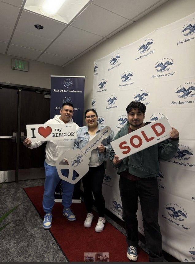 Three people are holding signs that say i love my realtor and sold.