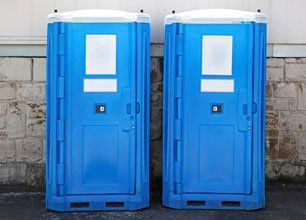 Two blue portable toilet cabins