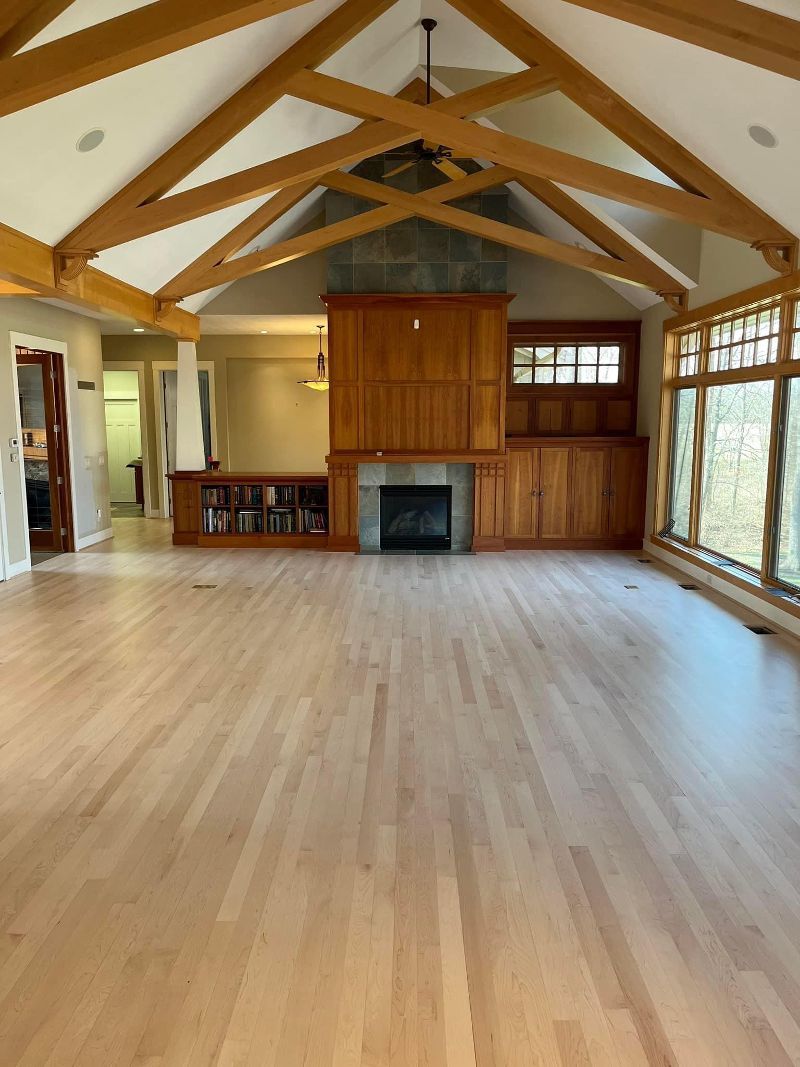 An empty living room with hardwood floors and a fireplace.