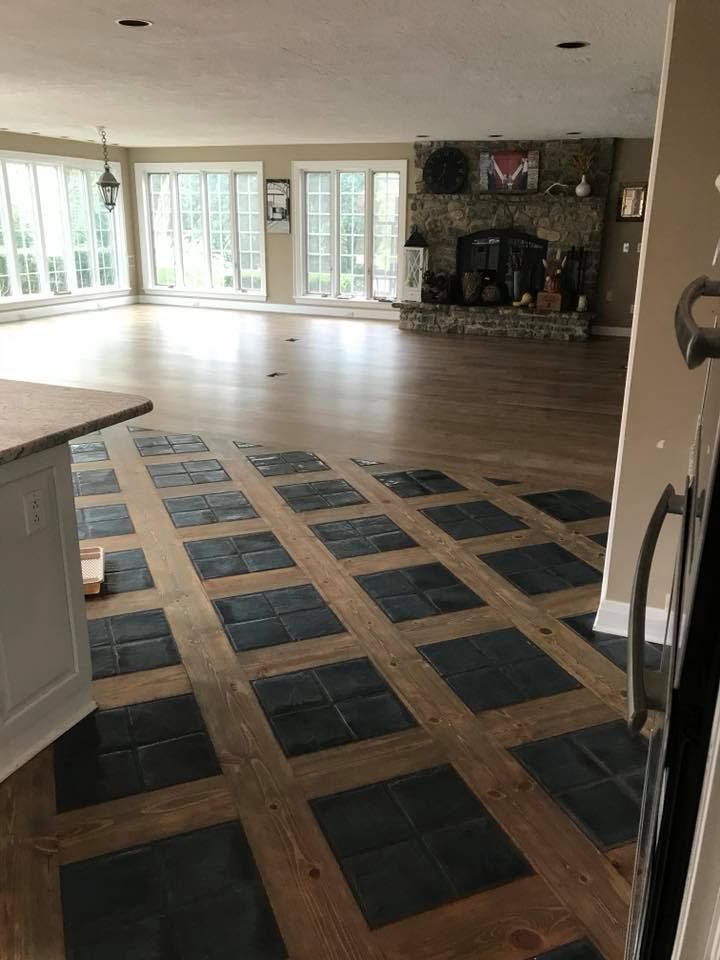 A large room with a wooden floor and a fireplace.