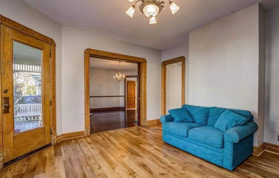 A living room with a blue couch and hardwood floors.
