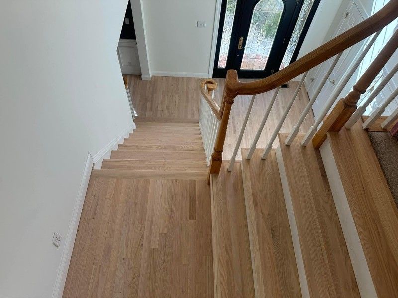 A wooden staircase with a white railing in a house.