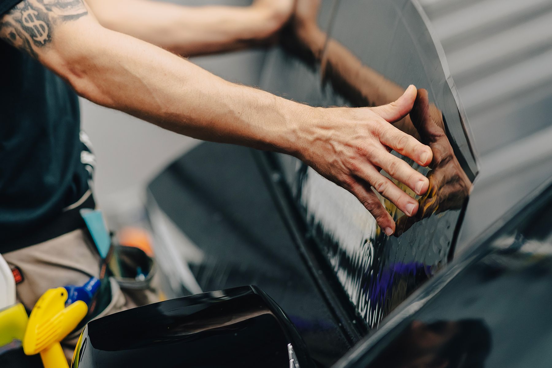 Person applying tint to a car window.