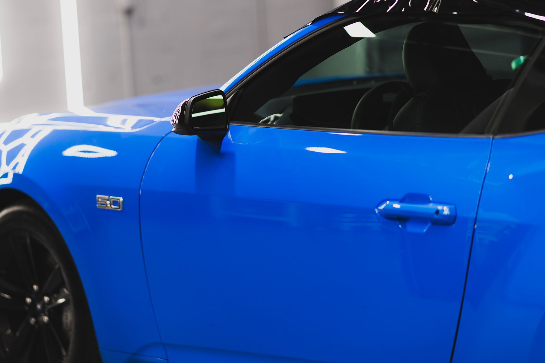 Blue Ford Mustang sports car with black accents.