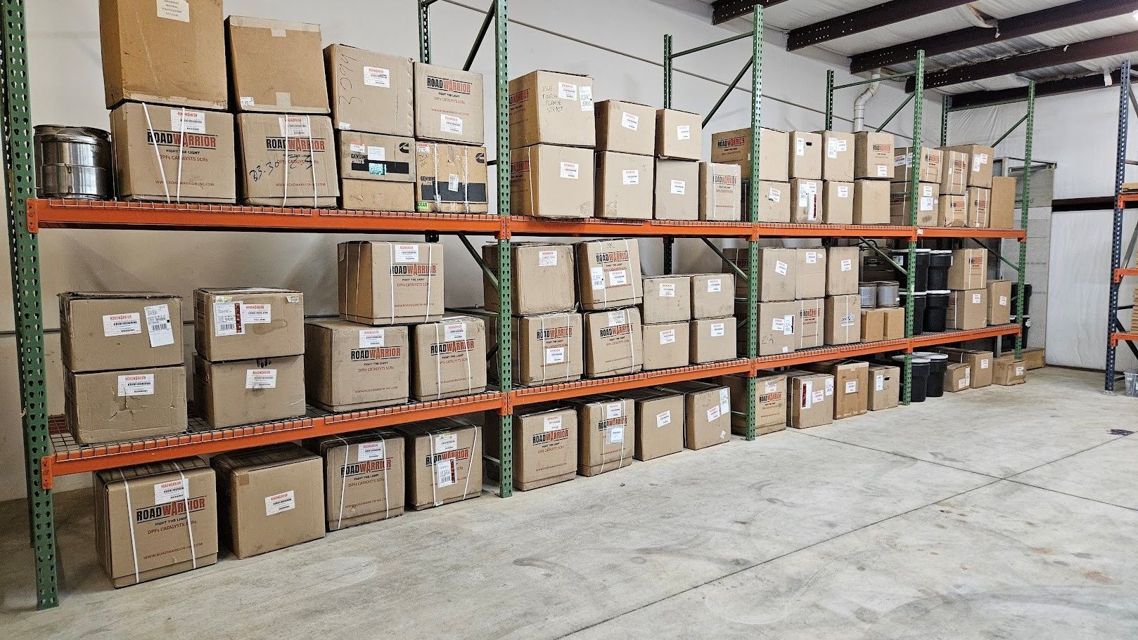 Industrial warehouse shelving units filled with numerous cardboard boxes stacked on metal racks.