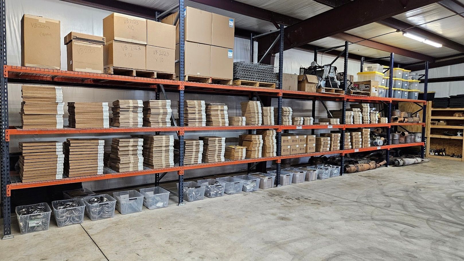A warehouse shelving unit featuring organized cardboard boxes and small industrial parts on metal racks.