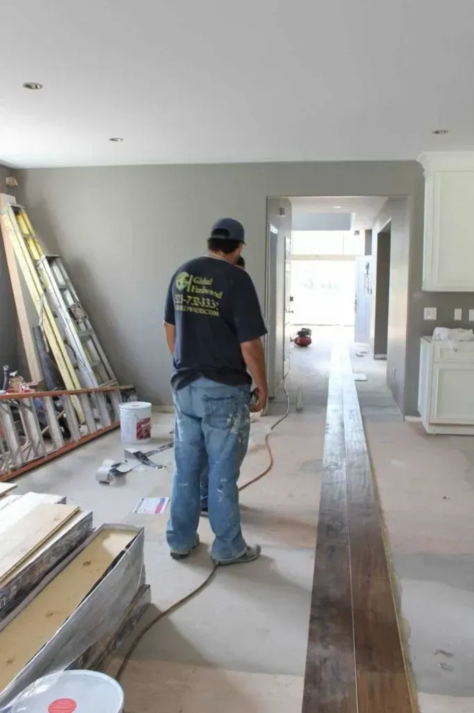 A man is standing in a hallway in a house under construction.