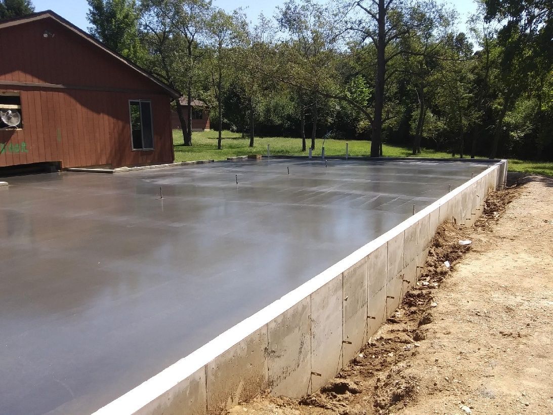 freshly cemented area with a red barn