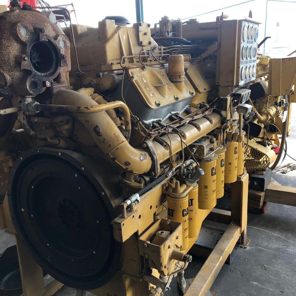 Yellow industrial diesel engine mounted on a pallet in a workshop