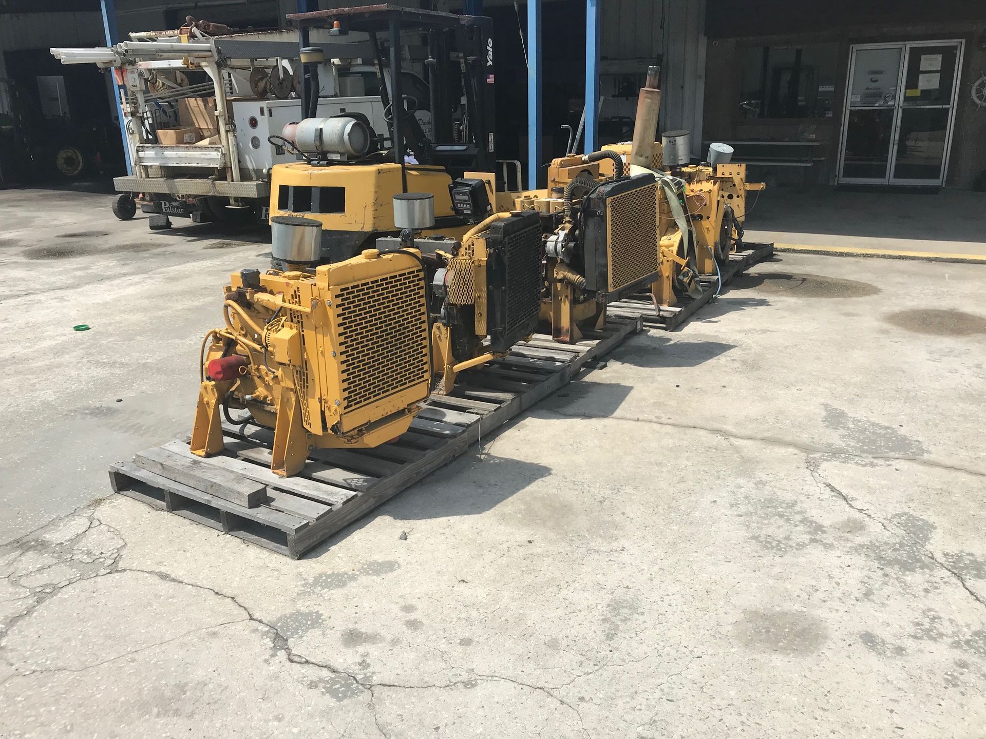 Yellow industrial equipment on pallets in a warehouse loading area