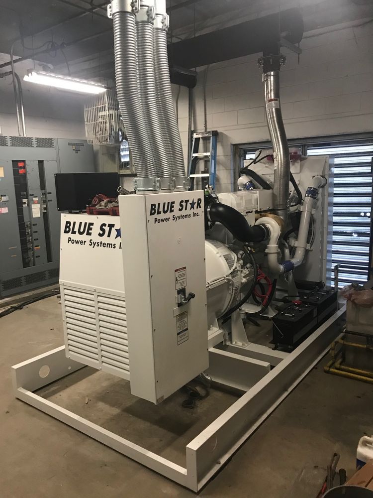 Blue Star industrial generator on a metal skid in a utility room, with large silver exhaust ducts.