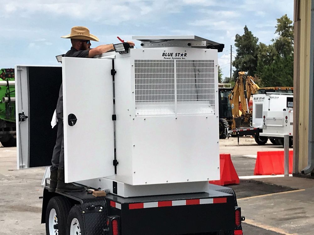 Worker standing on a small white utility machine near orange cones in a parking lot