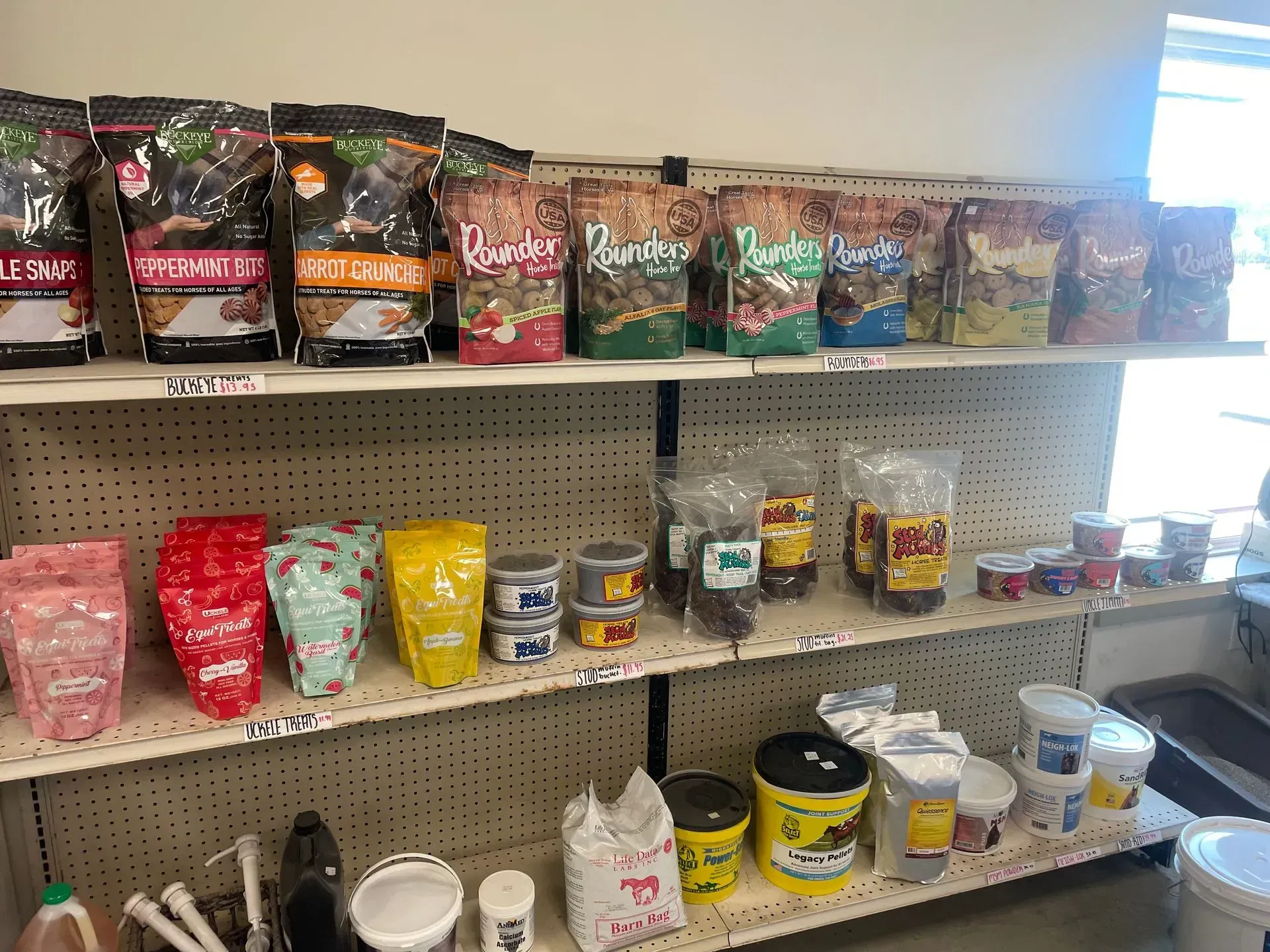 Shelves stocked with various pet food bags, cans, and other supplies in a store setting.