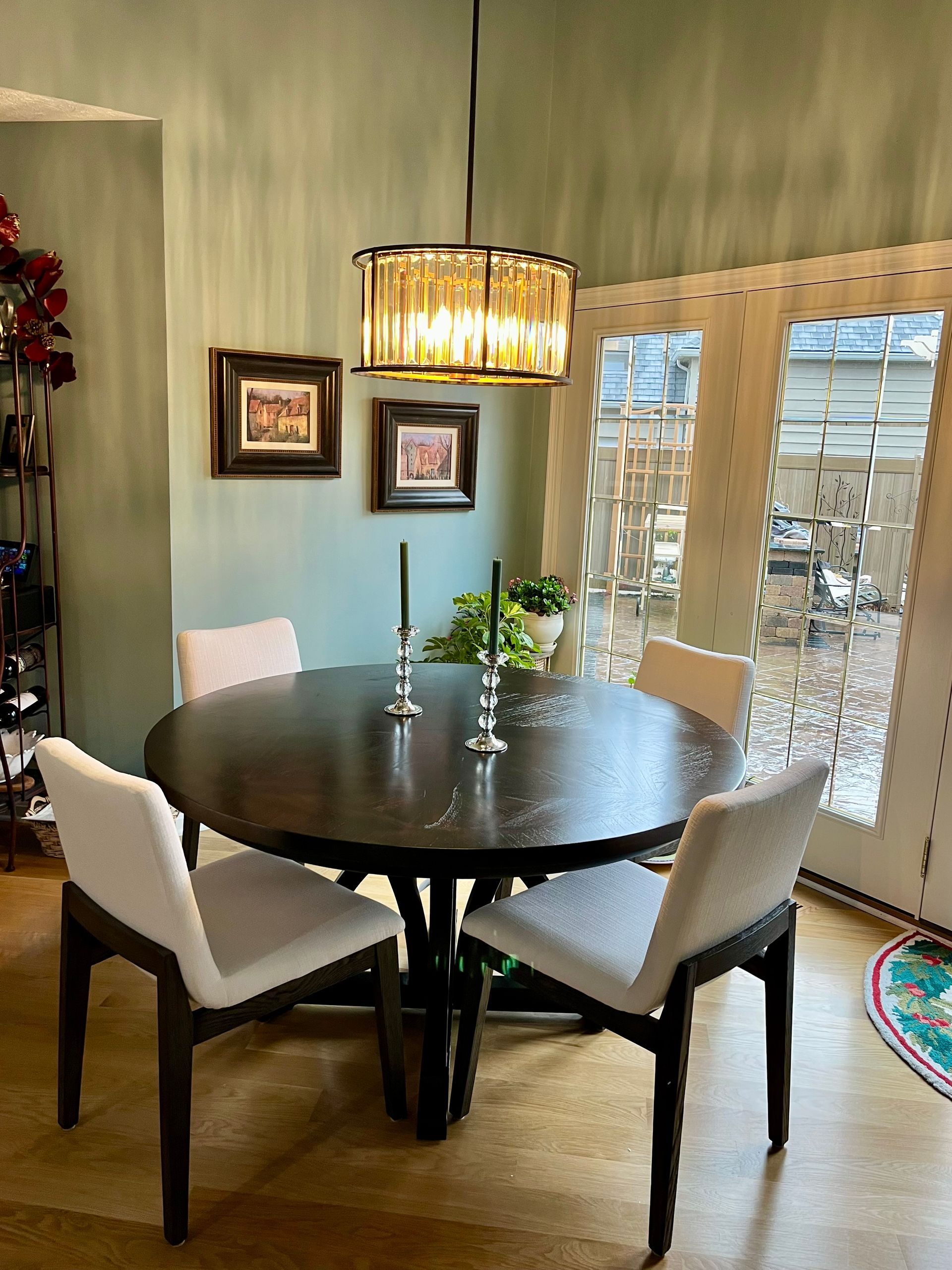 A dining room with a round table and white chairs