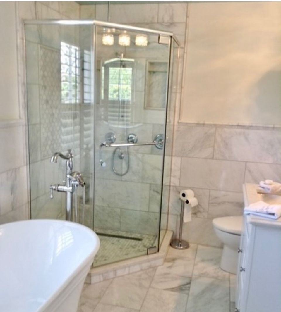 A bathroom with a tub a toilet and a shower