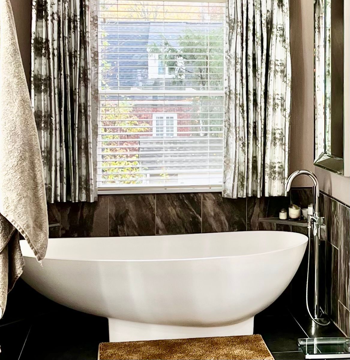 A bathroom with a tub and a window with blinds