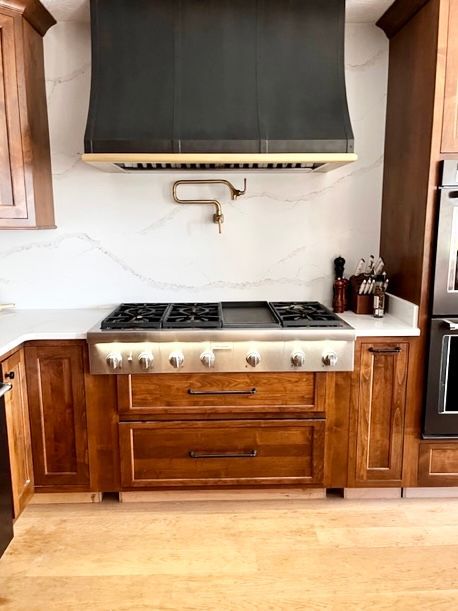 A kitchen with wooden cabinets and a stove top oven.