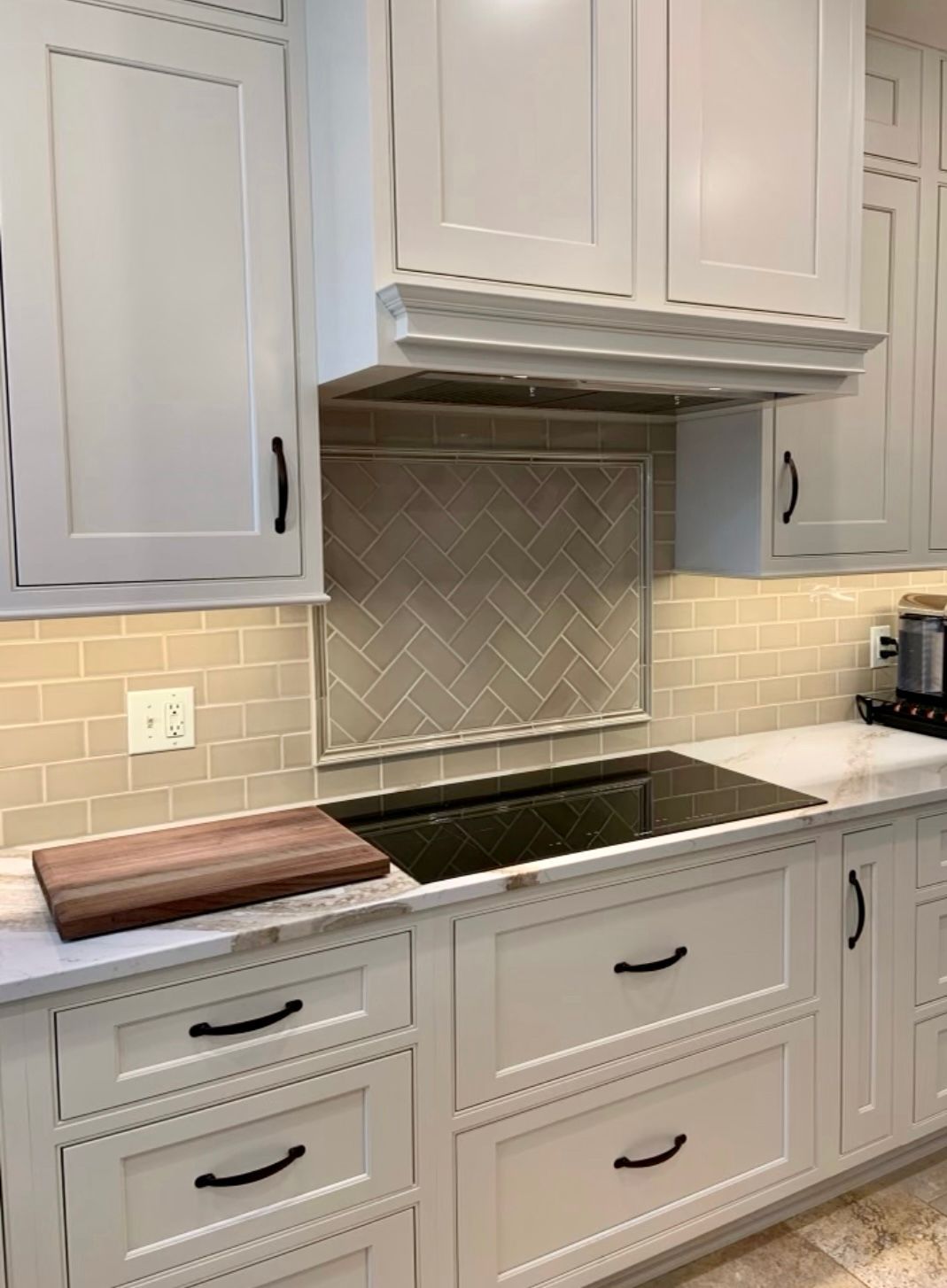 A kitchen with white cabinets and a stove top oven.