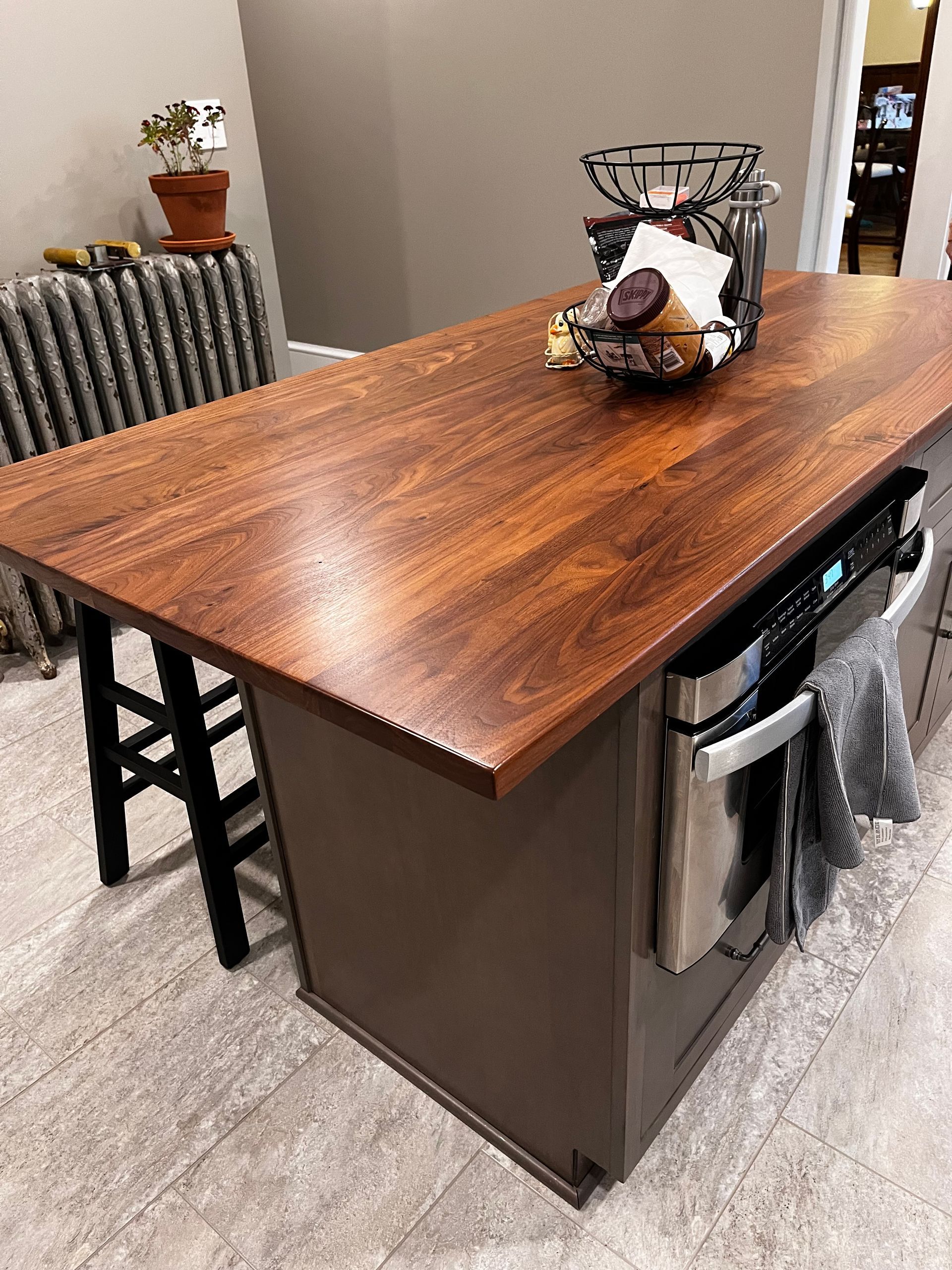 A kitchen island with a wooden counter top and stainless steel appliances.