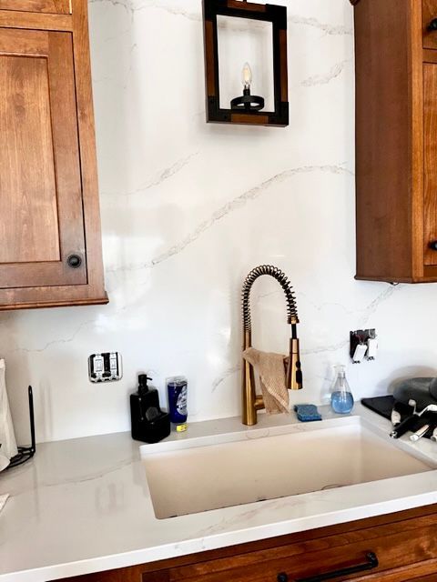 A kitchen sink with a faucet and wooden cabinets