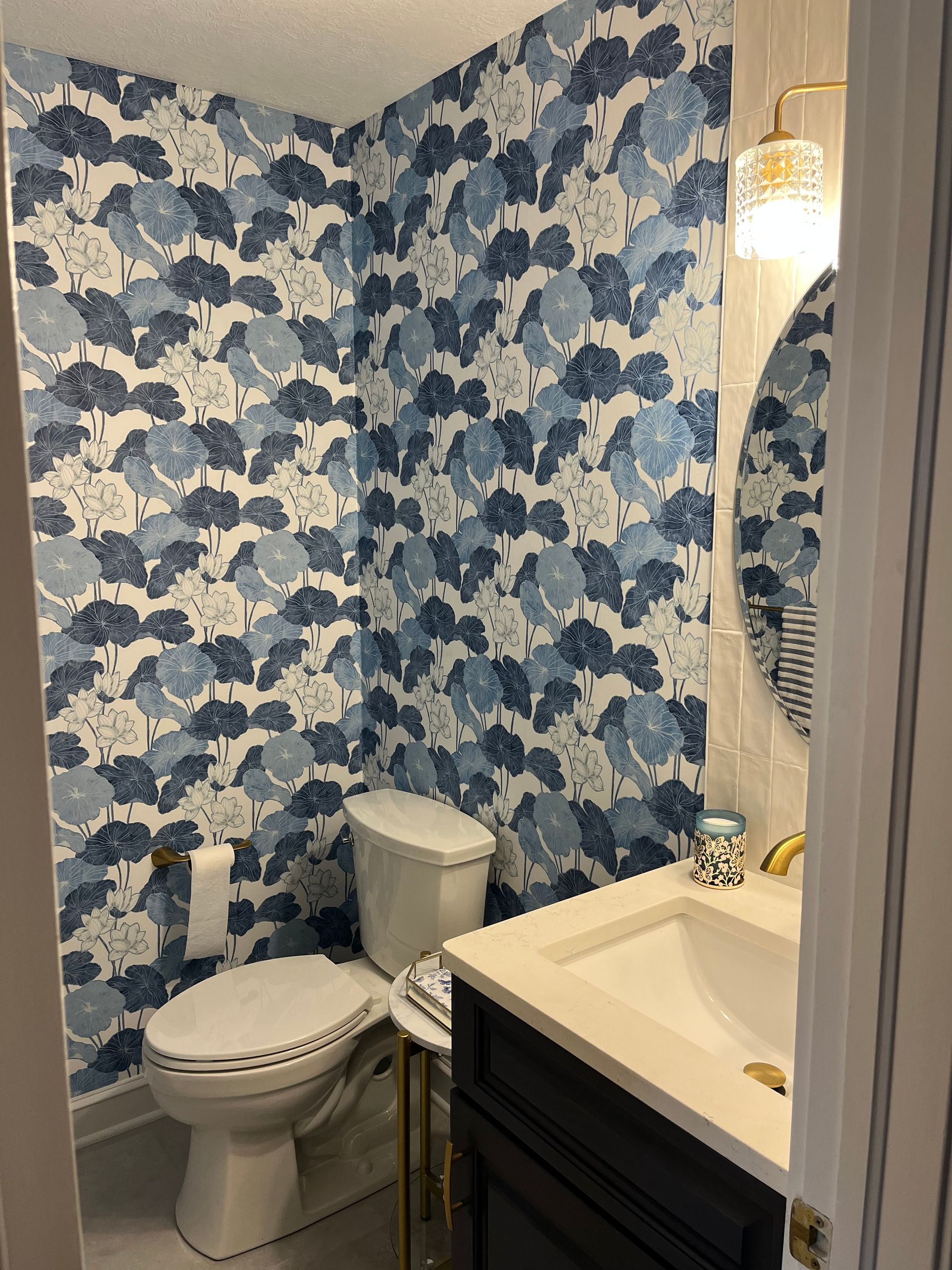 A bathroom with a toilet , sink and mirror.