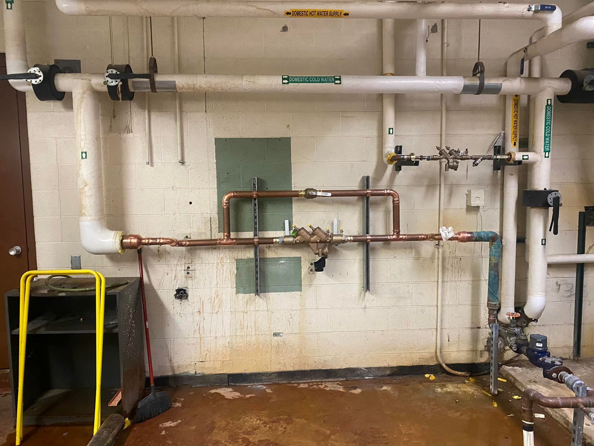 A room with a lot of pipes hanging on the wall.