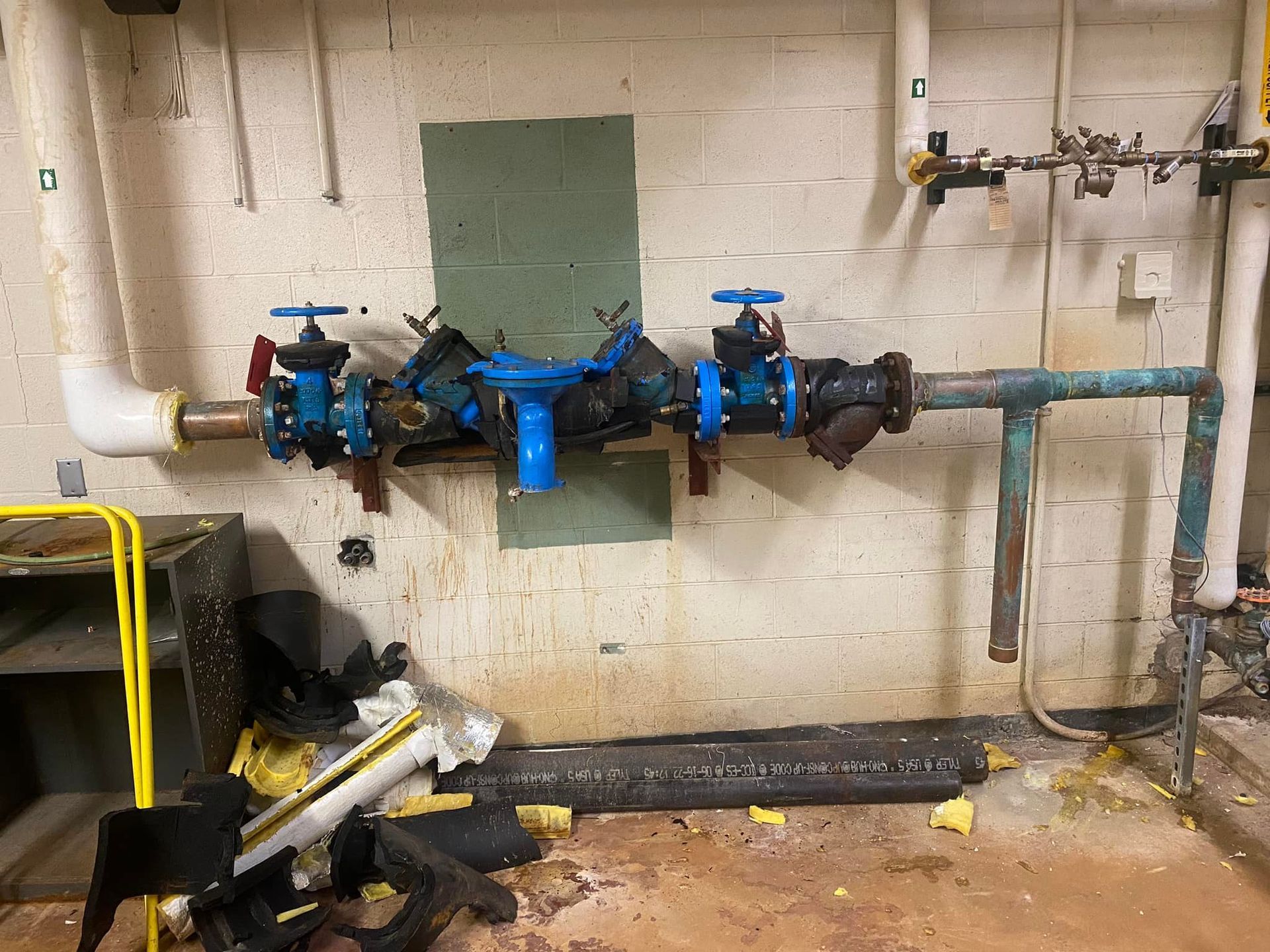 A room with a lot of pipes and valves on the wall.
