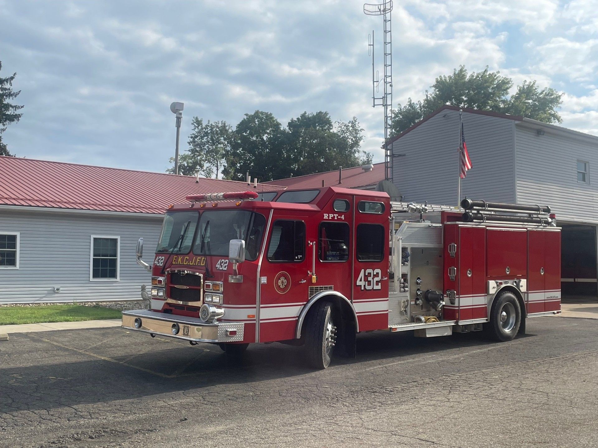 A red fire truck parked outside a building on a cloudy day.