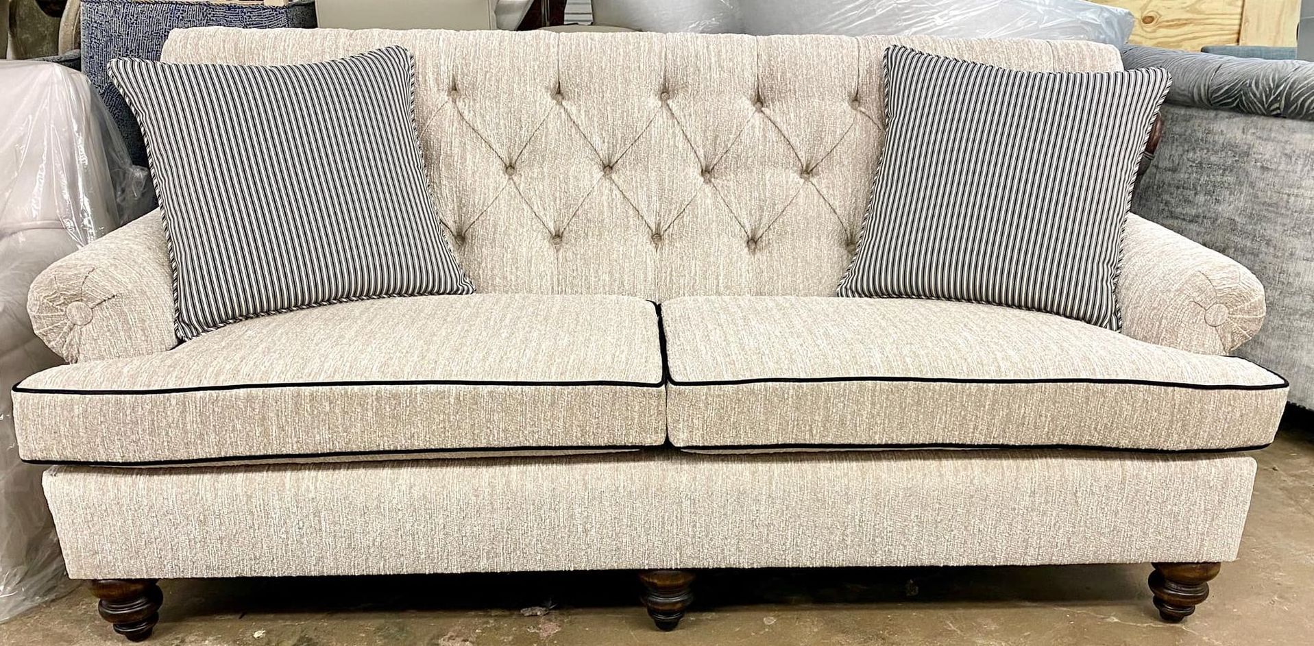 Custom built and upholstered sofa with a button tufted back. This sofa is upholstered with a neutral colored designer fabric. 