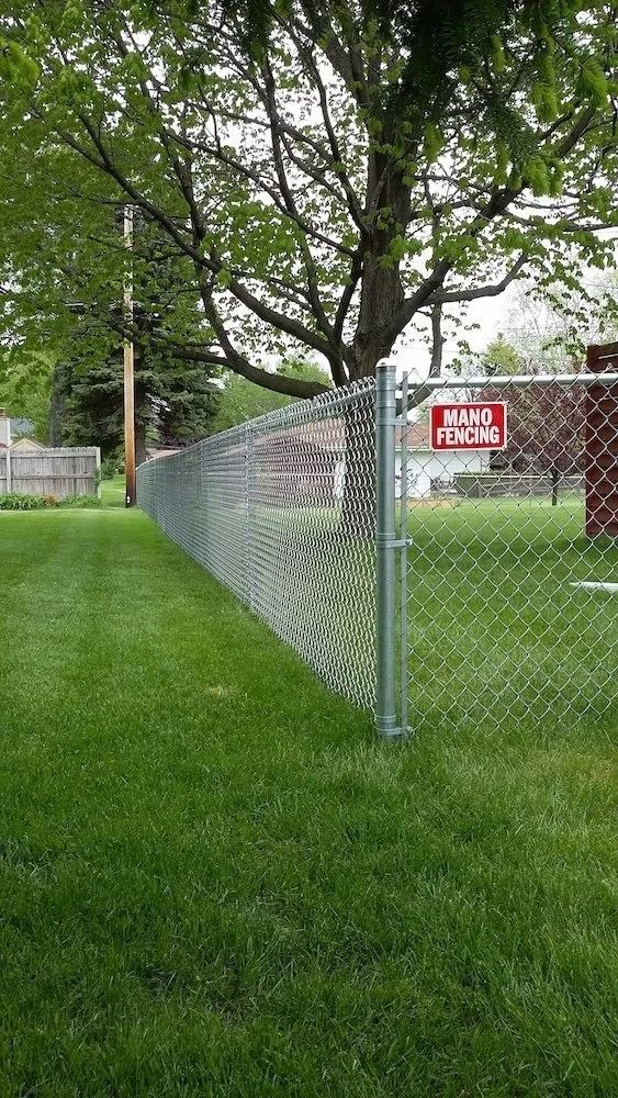 A chain-link fence topped with a red 