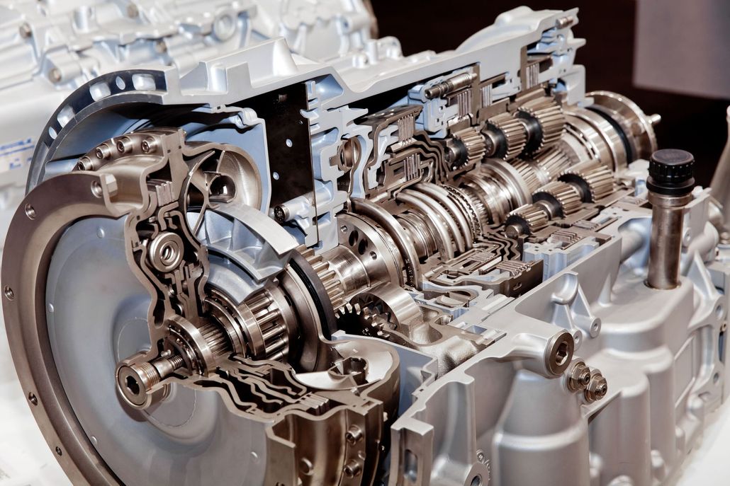 Cutaway view of a car engine showing internal gears, pistons, and metal components