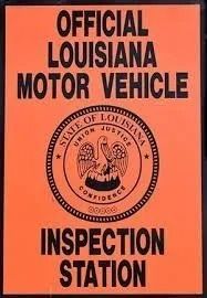 Orange sign reading “Official Louisiana Motor Vehicle Inspection Station” with state seal in the center